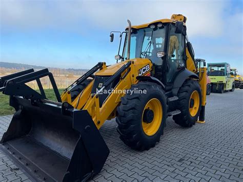 The JCB 4CX backhoe loader working in muddy construction site, showcasing its high ground clearance.