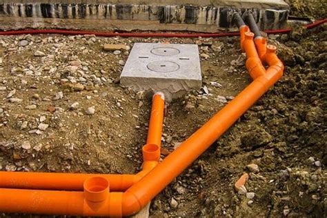 Galeria zdjęć przedstawiająca różne etapy prac budowlanych: kopanie fundamentów, układanie rur kanalizacyjnych, załadunek kruszywa na wywrotkę.