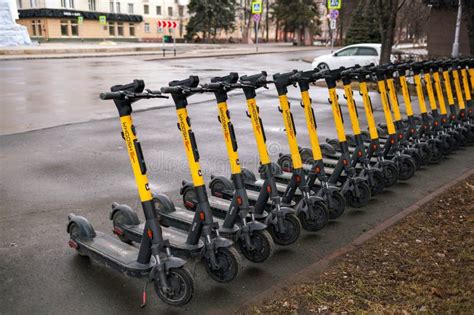 Thematic photo of a person collecting electric scooters for charging in a city at night