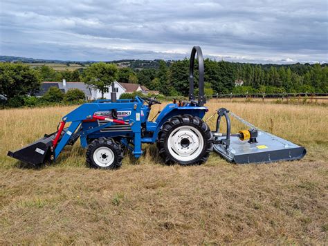 Thematic photo of an Iseki compact tractor with a green area in the background