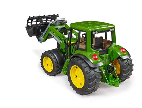 Ilustracja przedstawiająca ciągnik John Deere 6920 z ładowaczem Bruder, widziany z perspektywy frontowej, podkreślająca jego masywną konstrukcję i detale.