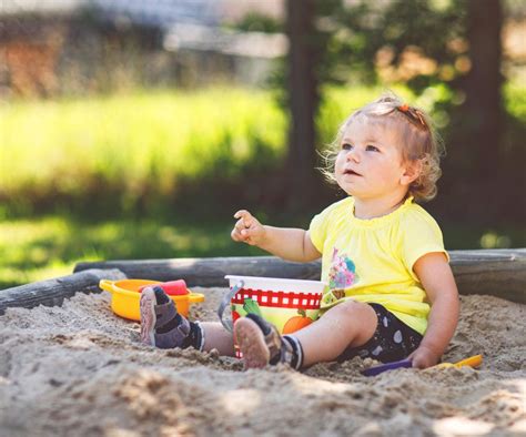 zdjęcie dziecka bawiącego się wywrotką Reks w piaskownicy
