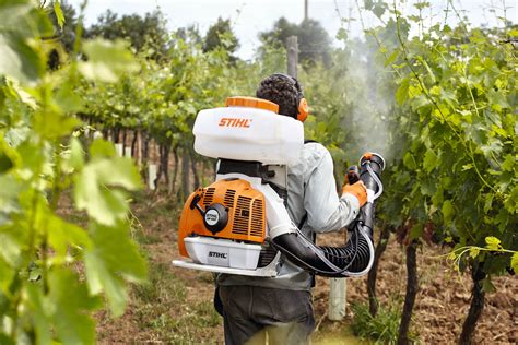 Zdjęcie opryskiwacza plecakowego spalinowego Stihl SR 450 w akcji, z widocznym strumieniem oprysku.