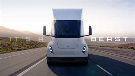 The Tesla Semi - a white electric semi-truck driving down a highway on a sunny day.