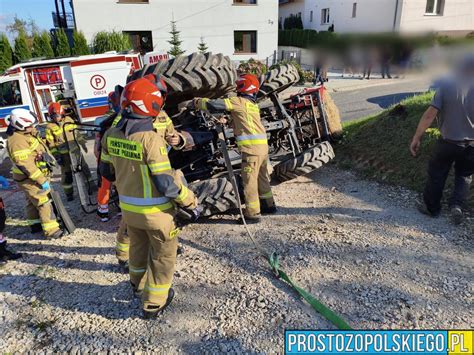 Strażacy podczas akcji ratowniczej po przewróceniu ciągnika rolniczego