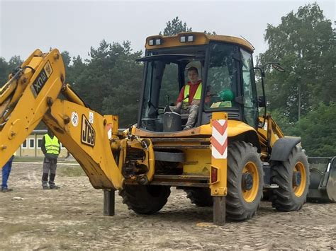 Tematyczne zdjęcie operatora koparko-ładowarki na placu budowy