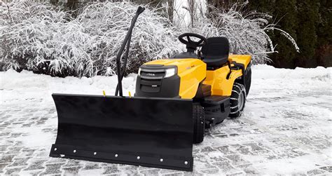 Mini traktor z zamontowanym pługiem do odśnieżania