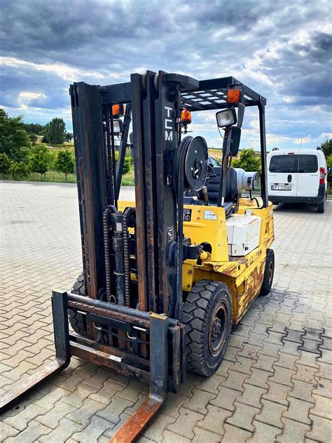 zdjęcie wózka widłowego Komatsu FD30 pracującego w magazynie