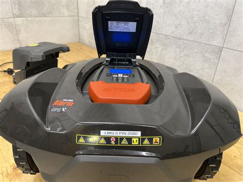 Schemat przedstawiający kosiarkę Husqvarna Automower 420 w ogrodzie z zaznaczonymi strefami koszenia i stacją ładującą