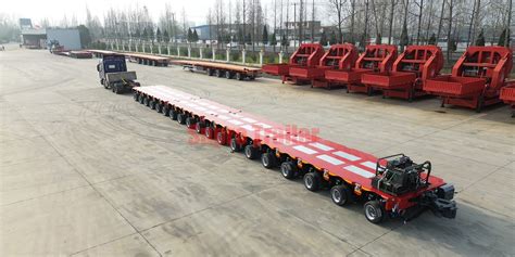 Photo of the oversized column being transported on a specialized modular trailer.