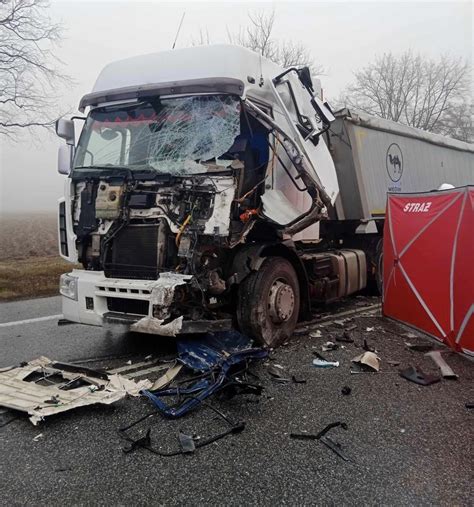 Zdjęcie przewróconej ciężarówki Scania na drodze krajowej nr 11, z rozrzuconym ładunkiem i służbami porządkowymi