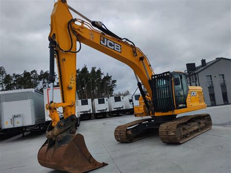 Wnętrze kabiny koparki JCB 220 z widocznym panelem sterowania i klimatyzacją