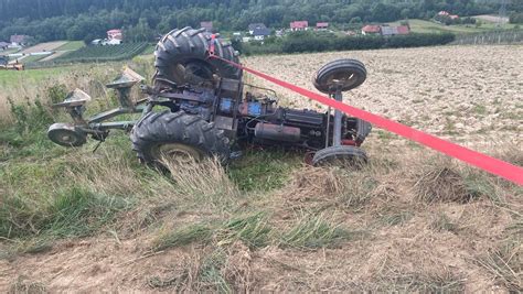 Zdjęcie przedstawiające przewrócony ciągnik rolniczy na skarpie