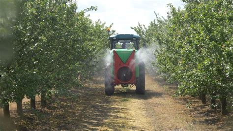 Opryskiwacz sadowniczy na tle sadu owocowego