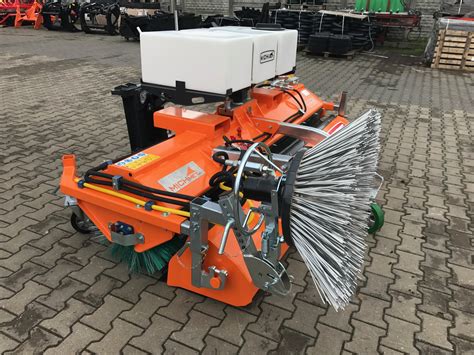 Zamiatarka czołowa JCB z widocznymi szczotkami walcowymi