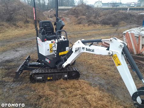 zdjęcie mechanika serwisującego koparkę Bobcat
