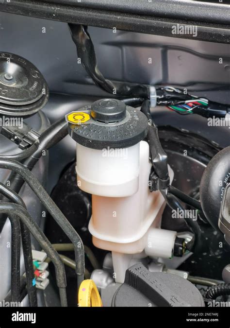 Thematic photo of a car engine compartment with a focus on the windshield washer fluid reservoir.