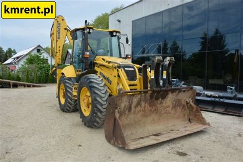 Schematyczny przekrój koparko-ładowarki Komatsu z zaznaczonymi kluczowymi komponentami hydraulicznymi
