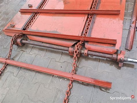 Zbliżenie na mechanizm podający rozrzutnika obornika - łańcuchy i rolki