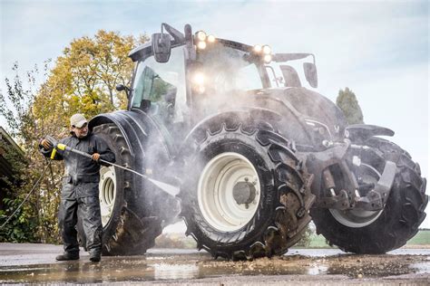 Rolnik myje ciągnik myjką ciśnieniową