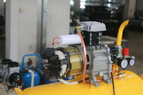 Tematyczne zdjęcie sprężarki powietrza z podłączonym młotem pneumatycznym
