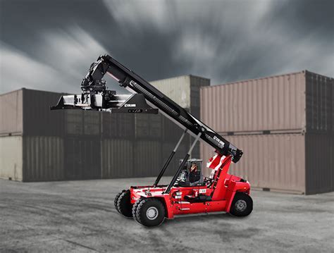 Zdjęcie przedstawiające reachstacker Kalmar ładujący duży element wieży wiatrowej.