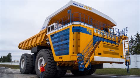 Zbliżenie na ogromne koło wozidła BelAZ 75710 z widoczną porównawczą skalą