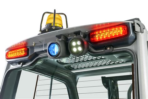 Schemat przedstawiający działanie systemu STILL SafetyLight 4plus z niebieskimi punktami świetlnymi na podłodze.