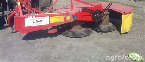 Zdjęcie kosiarki rotacyjnej z bliska, ukazujące mechanizm tnący.