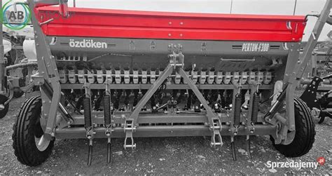 Widok zbiornika ziarna siewnika z otwartą pokrywą i mechanizmem sprężynowym