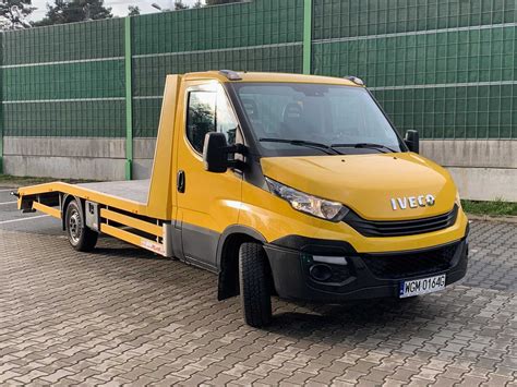 Zdjęcie Iveco Daily w wersji lawety z załadowanym na nią samochodem.