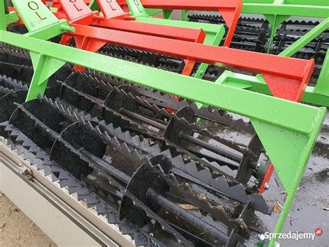 Zbliżenie na elementy robocze agregatu: zęby, talerze i wał doprawiający.