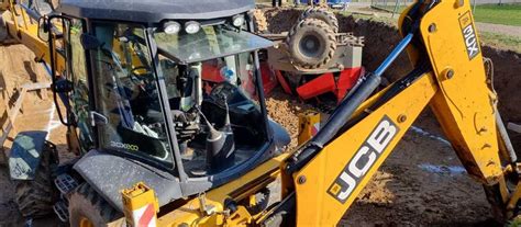 Zdjęcie mobilnego serwisu JCB w akcji, naprawiającego maszynę na placu budowy
