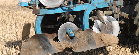 Zdjęcie pługa obrotowego Agro-Tom DSL w akcji, pokazujące jego pracę na polu.