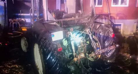 zdjęcie rozbitego ciągnika rolniczego przy drzewie