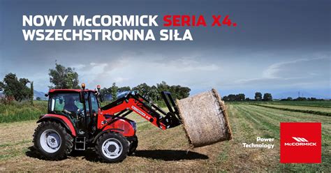Zdjęcie ciągnika z ładowaczem czołowym Agrolux, który transportuje bele słomy