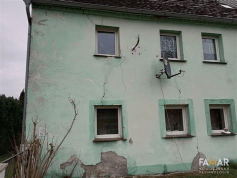 zdjęcie uszkodzonej ściany budynku po uderzeniu przyczep