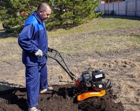 Zdjęcie glebogryzarki spalinowej w trakcie pracy w ogrodzie.