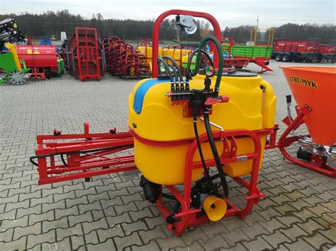 Opryskiwacz polowy ciągnikowy z szeroką belką roboczą.
