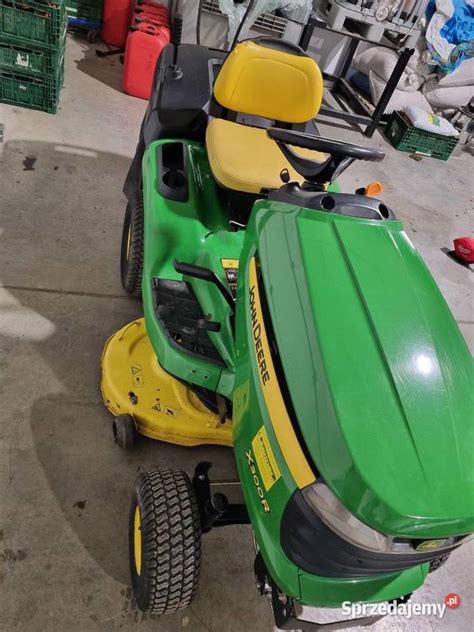 zdjęcie traktorka John Deere X155R z koszem na trawę