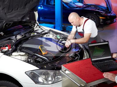 zdjęcie mechanika wykonującego diagnostykę silnika ciągnikowego