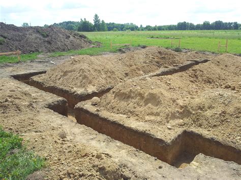 Schematyczny rysunek koparko-ładowarki wykonującej wykop pod fundamenty