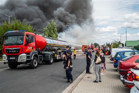 Strażacy gaszą płonącą koparko-ładowarkę w hali magazynowej