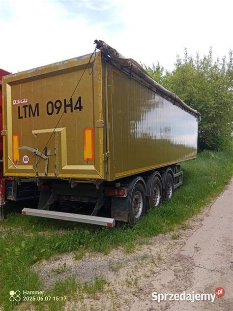 Schemat naczepy wywrotki z zaznaczonym nisko położonym środkiem ciężkości i krawędzią załadunkową