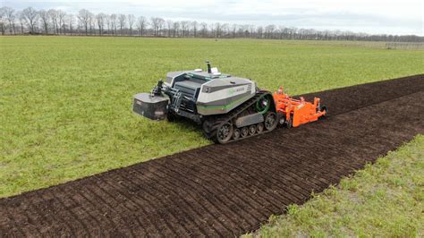 Zdjęcie autonomicznego ciągnika AgBot 5.115T2 pracującego w polu z pługiem Kverneland