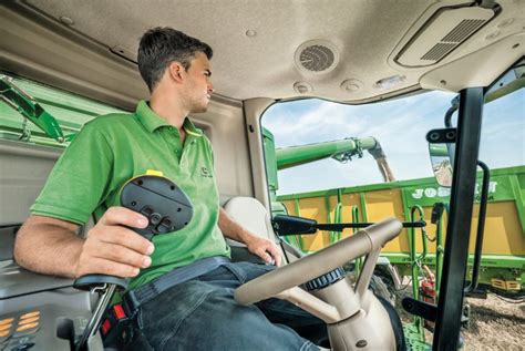 operator kombajnu w nowoczesnej kabinie z wyświetlaczami