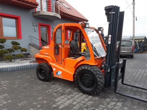 Terenowy wózek widłowy AUSA, transportujący ładunek po nierównym terenie