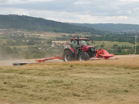 Ilustracja przedstawiająca nowoczesną kosiarkę dyskową pracującą na polu