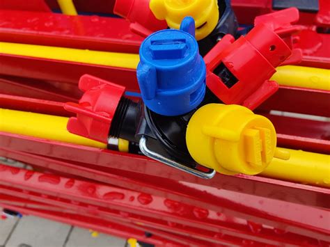 Ilustracja przedstawiająca czyszczenie dyszy opryskiwacza.