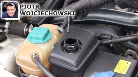 Zbiornik płynu hydraulicznego przyczepy wywrotki z zaznaczonym poziomem płynu.